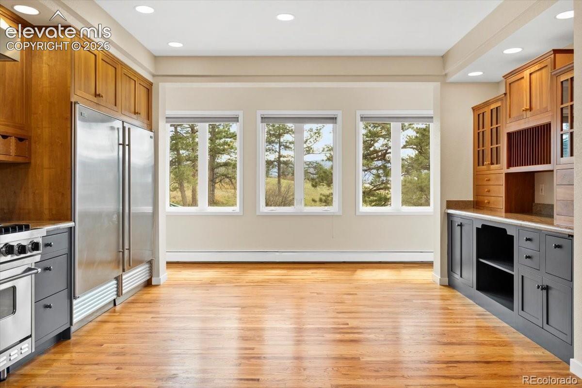 Spacious room featuring wood-finish flooring, recessed lighting, and three large windows