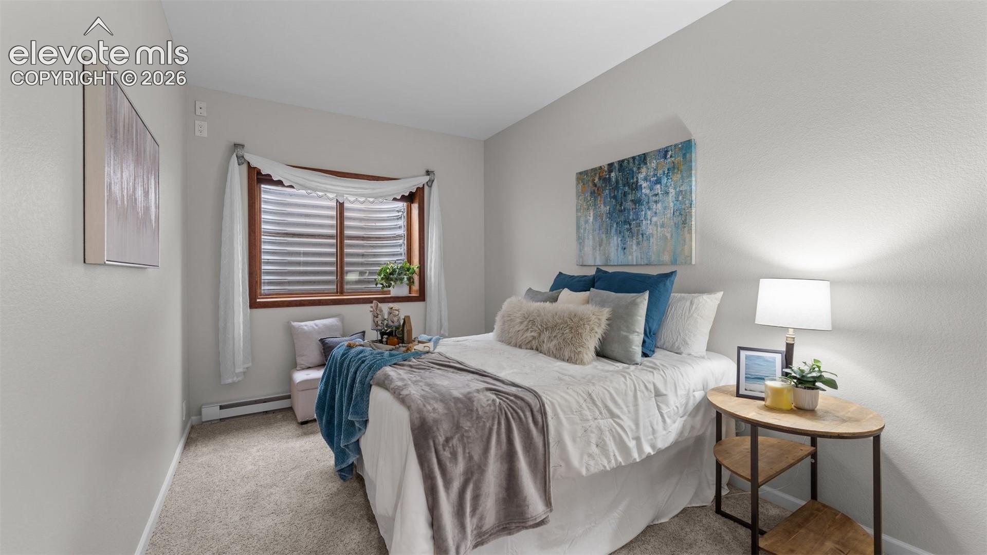 Neutral-toned interior space featuring wall-to-wall carpeting and a window with wood-finish trim