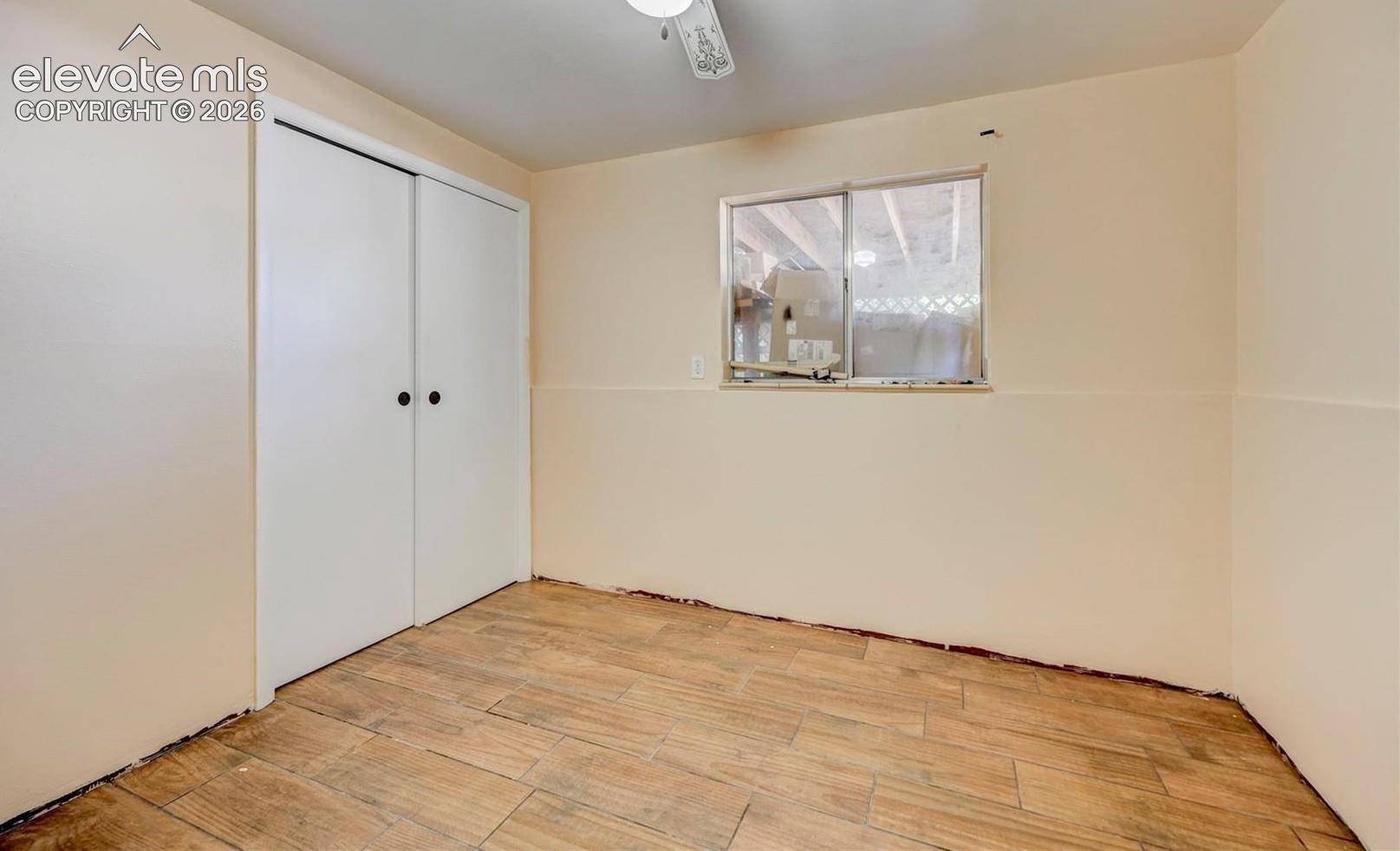 Wood-finish tile flooring, dual-panel sliding closet doors, and a horizontal sliding window