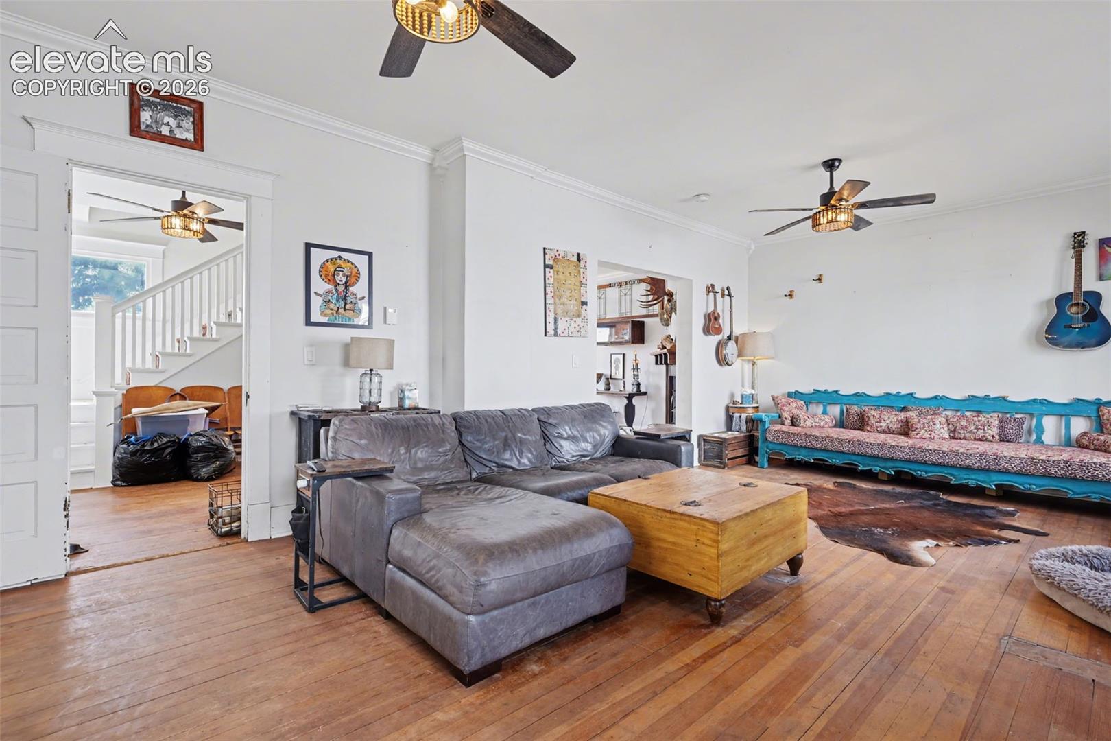Living / Dining area with ceiling fan, crown molding, hardwood, and large windows for natural lighting