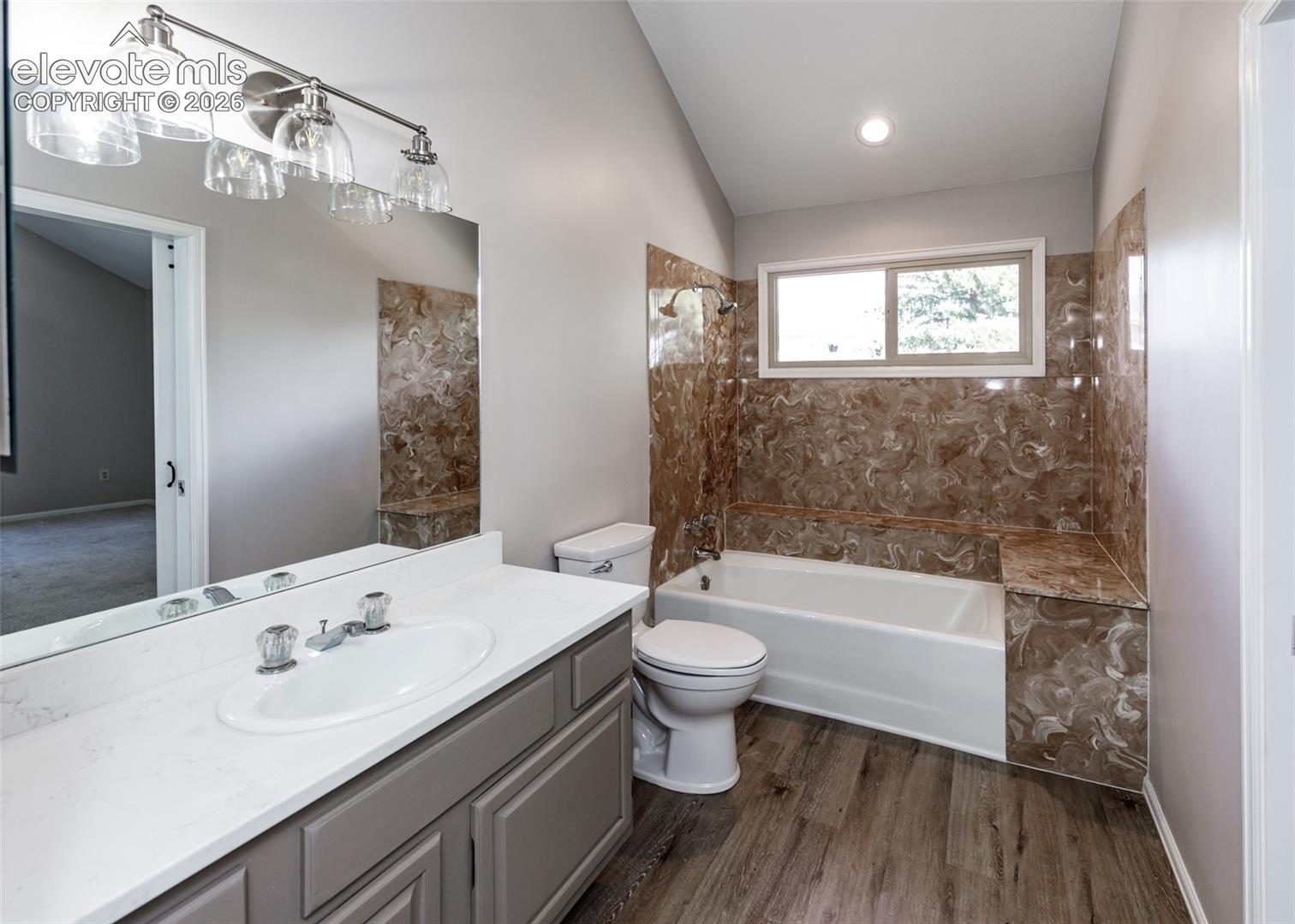 Vanity with a single basin, brushed nickel faucet, and a large mirror