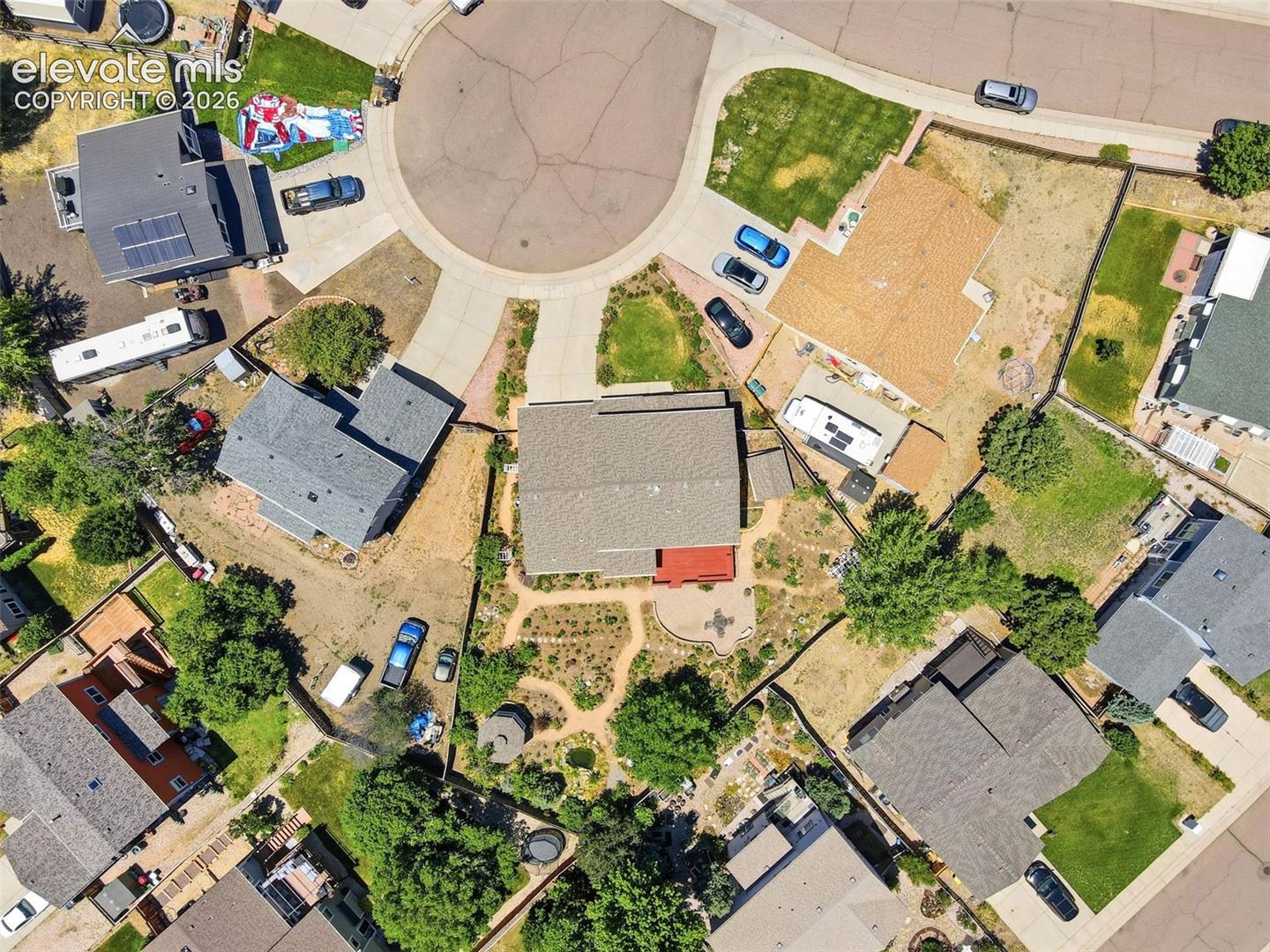 Cul-de-sac property featuring a large backyard with mature trees, a stone patio, and a dedicated garden area