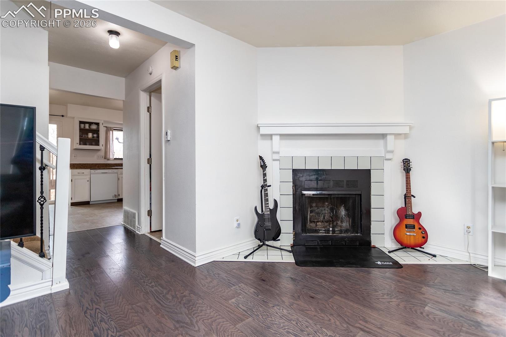 Living area featuring wood finished floors and a tiled fireplace
