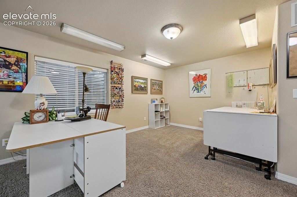 Neutral wall color, window with horizontal blinds, overhead fluorescent lighting, and recessed ceiling light fixture