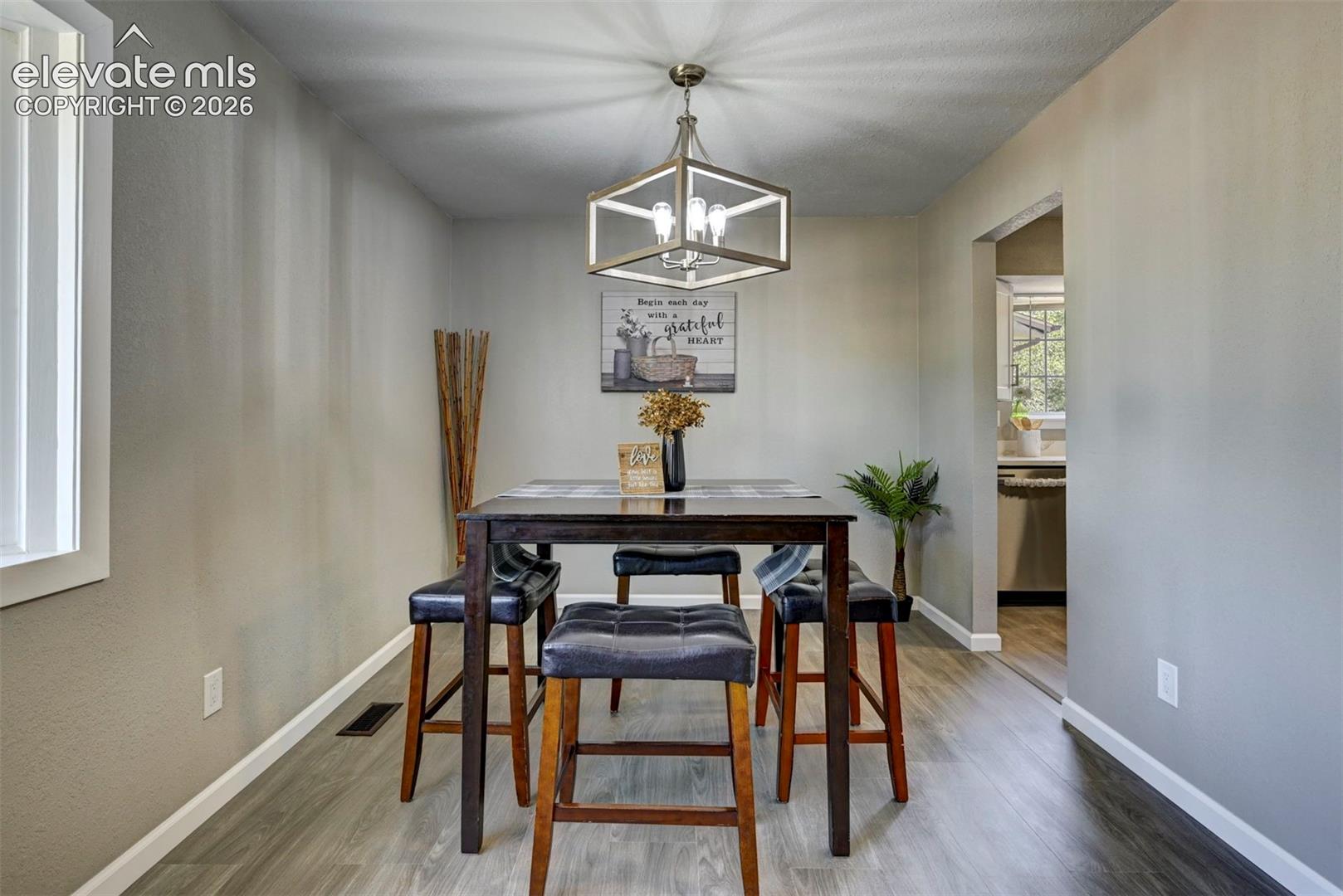 Dining area featuring wood-finish flooring and a geometric metal frame chandelier