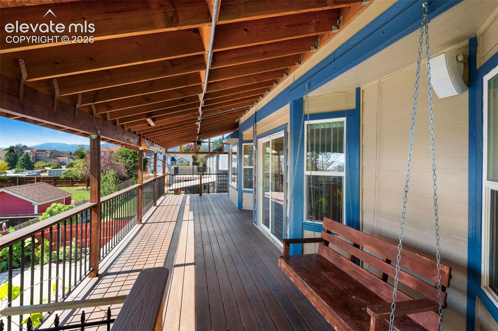 Expansive covered deck with composite decking and exposed wood ceiling beams