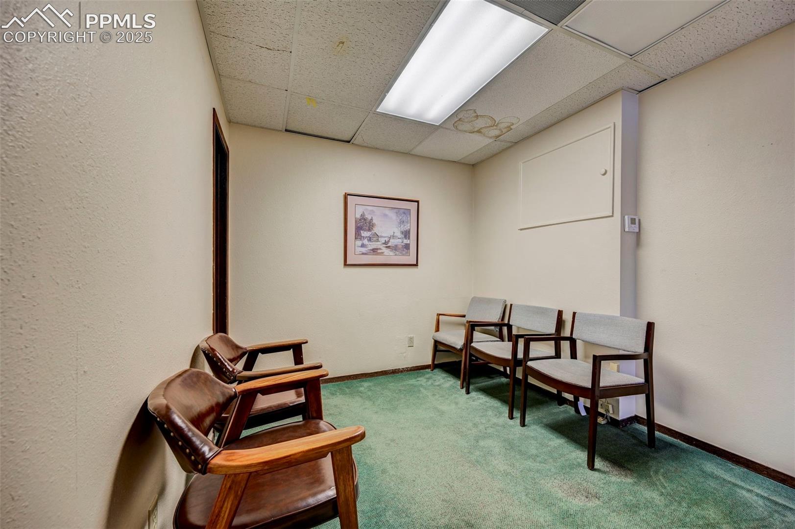 Sitting room featuring a paneled ceiling, carpet, and baseboards
