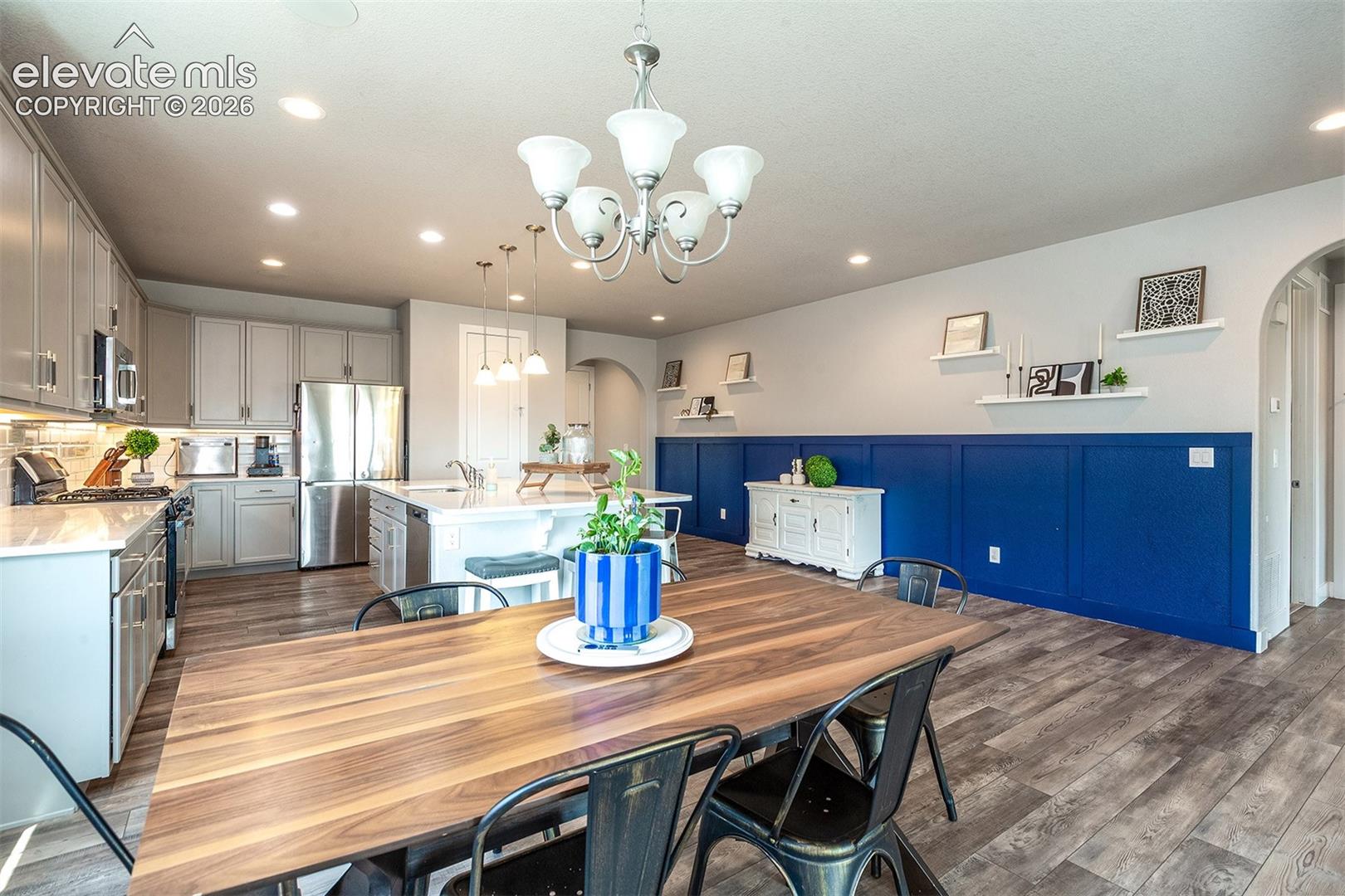 Dining area featuring a wood-finish table, a five-light chandelier, and multiple windows 