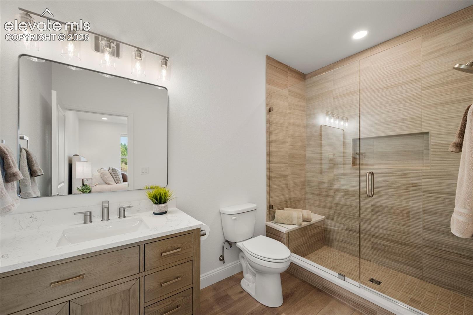 Shower with a glass enclosure, a built-in bench, and a recessed niche