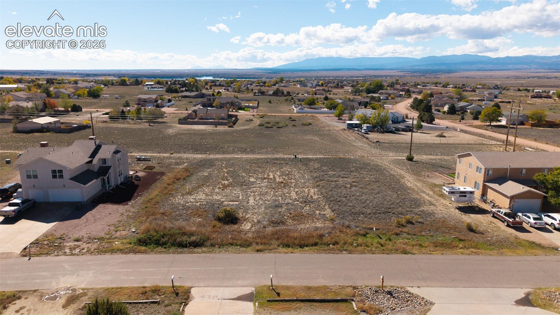 Vacant parcel featuring paved road access, utility service proximity, and expansive mountain range scenery