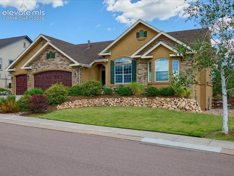 Elegant single-story residence featuring a stucco and stone exterior with arched architectural details