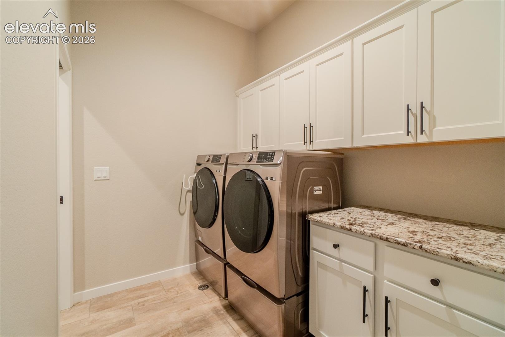 Dedicated laundry area featuring light wood-finish flooring