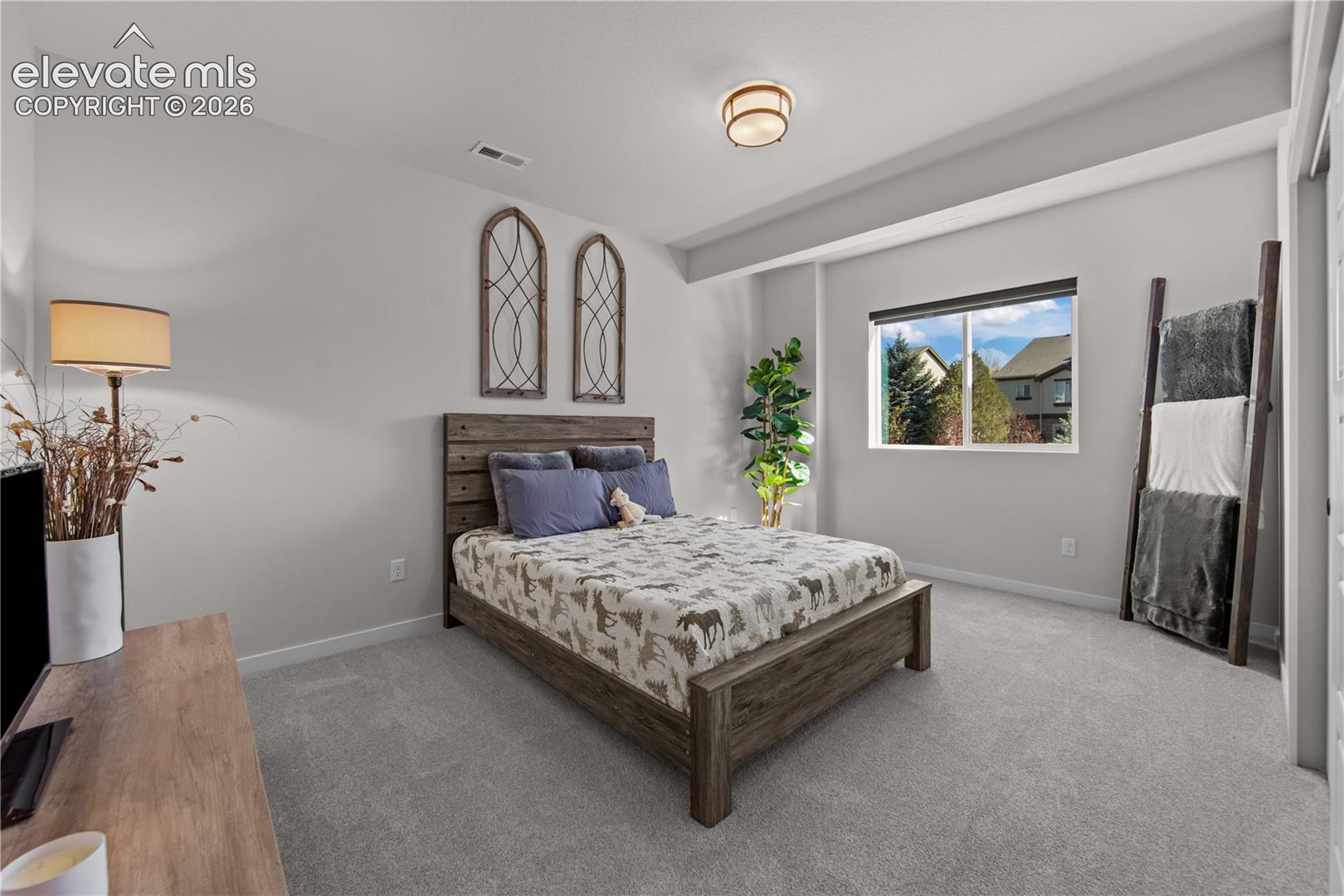 Neutral wall coloring, wall-to-wall carpeting, recessed ceiling lighting, and a single-pane window