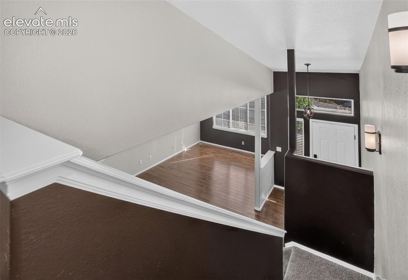 Hardwood-style flooring, white paneled door, horizontal window, and recessed lighting