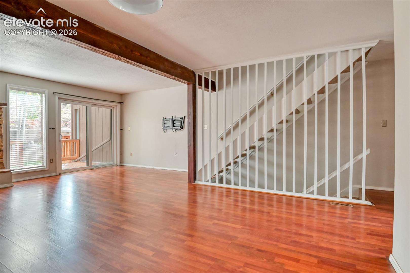 Hardwood-finish flooring, exposed wooden beam, and sliding glass door
