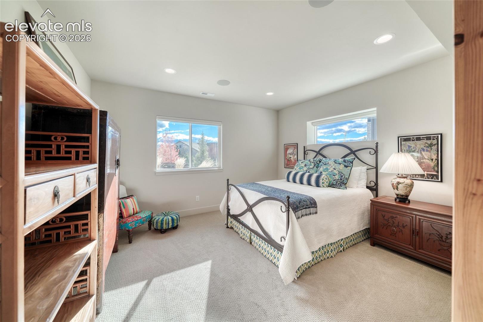 Neutral-toned carpeted flooring, recessed ceiling lighting, and dual windows