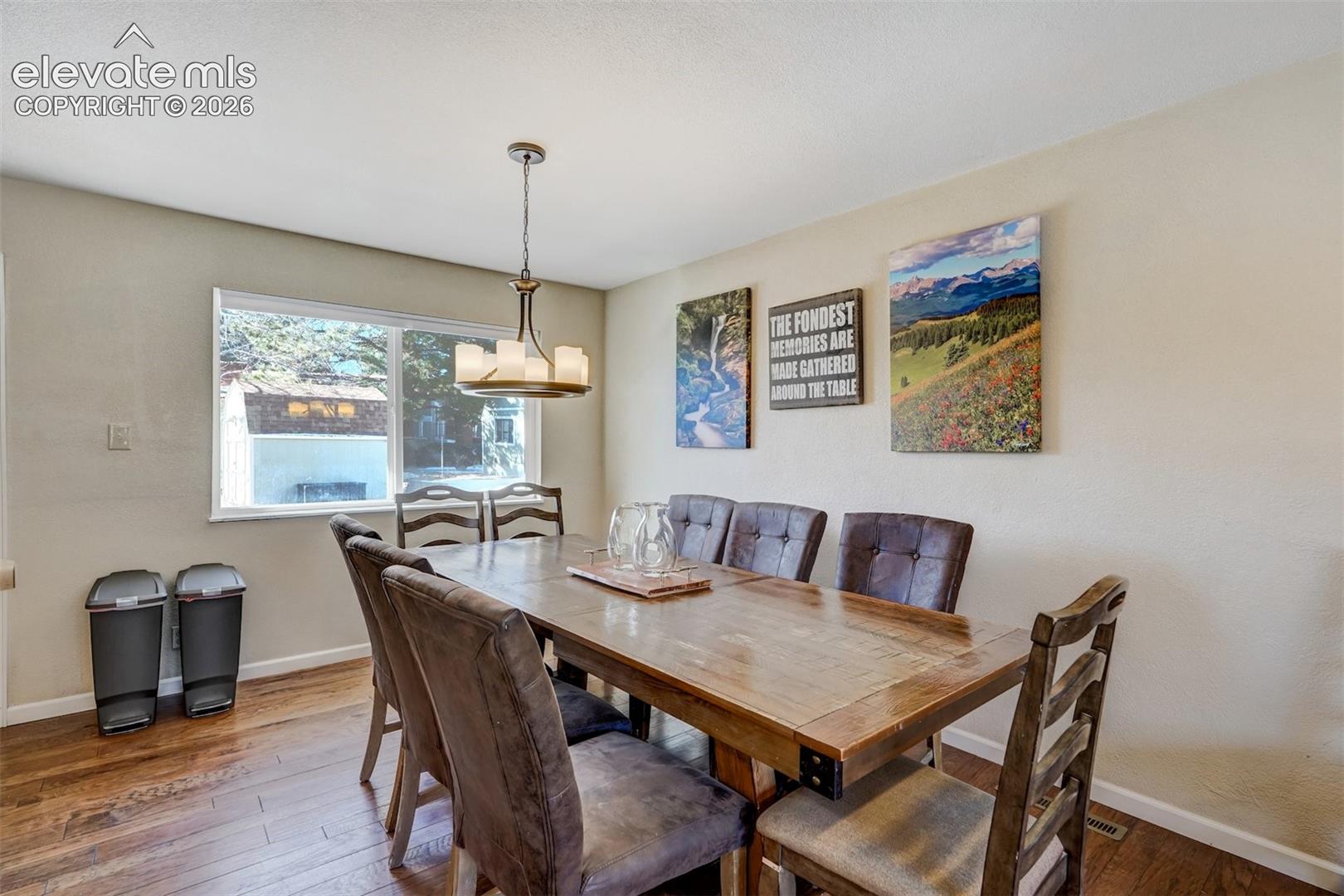 Hardwood flooring, painted walls, window with trim, and a ceiling-mounted light fixture