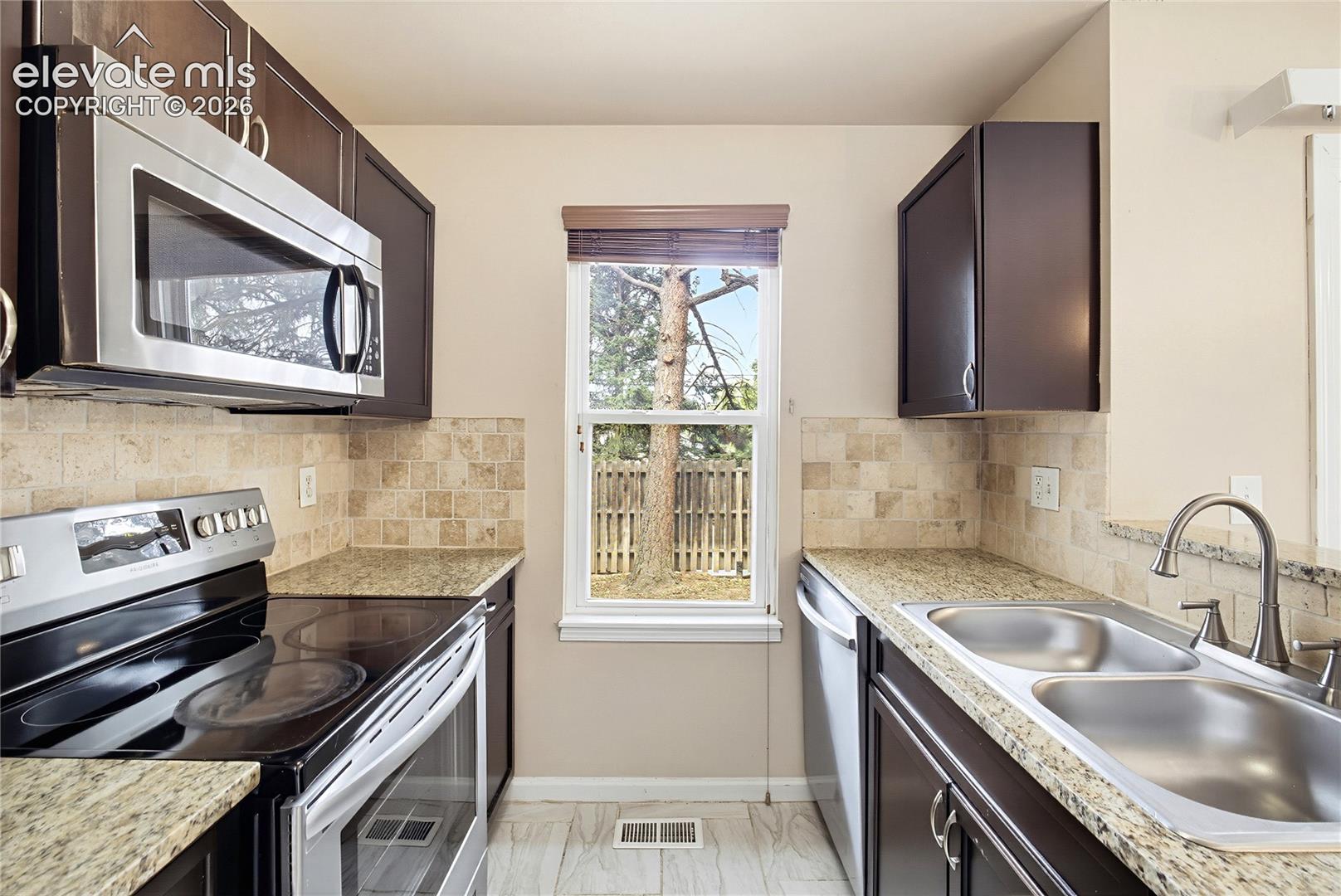 Kitchen with double stainless steel sink and window to the backyard.