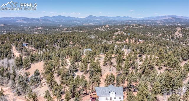Bird's eye view of a mountain backdrop and a heavily wooded area