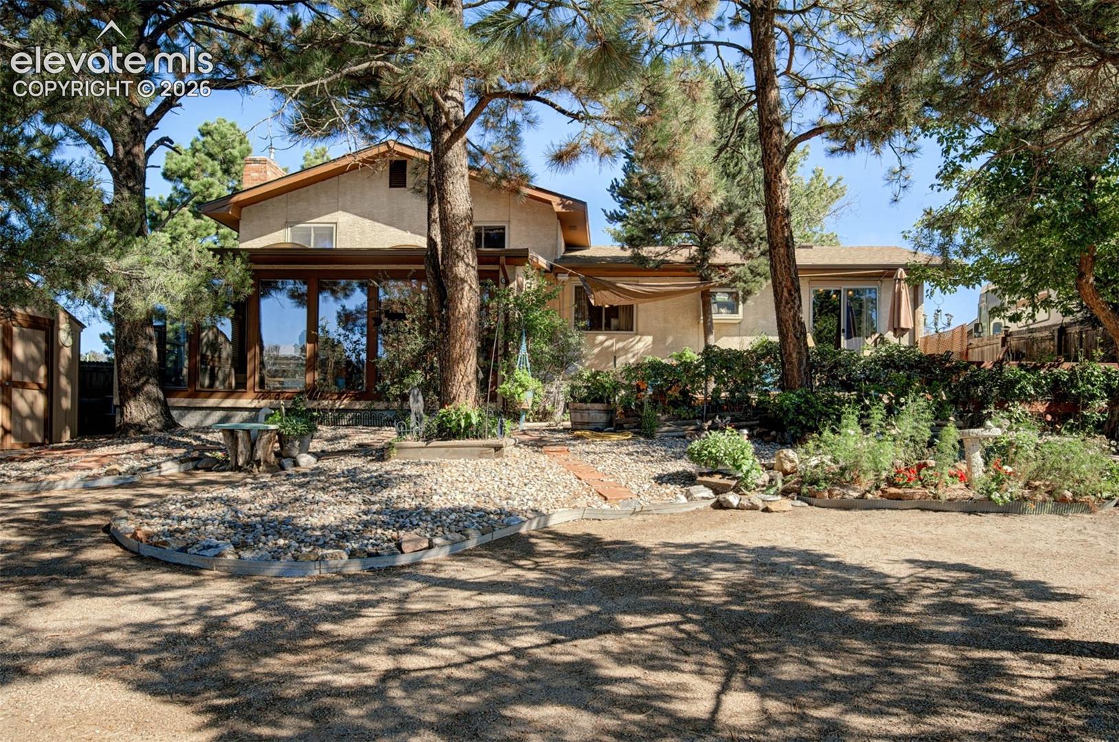 Terraced landscaping with mature trees and a gravel pathway