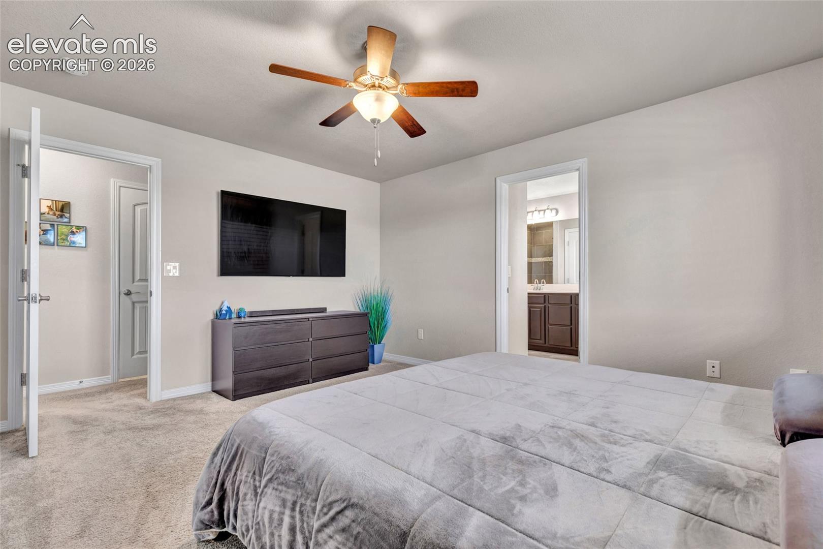 Carpeted room with a ceiling fan