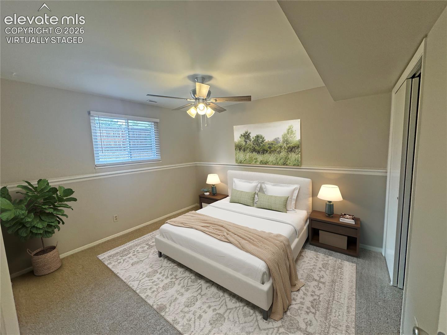 virtually staged Neutral-toned room featuring horizontal chair rail molding, ceiling-mounted paddle fan with light kit, and bi-fold closet doors