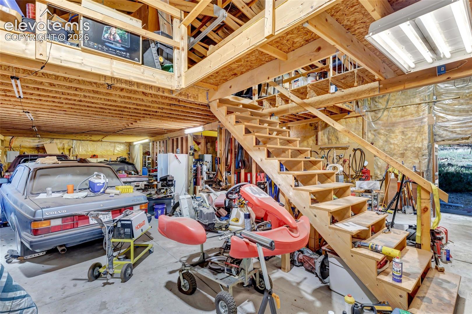 Exposed wood beam ceiling, open-tread wood staircase, and an upper loft area