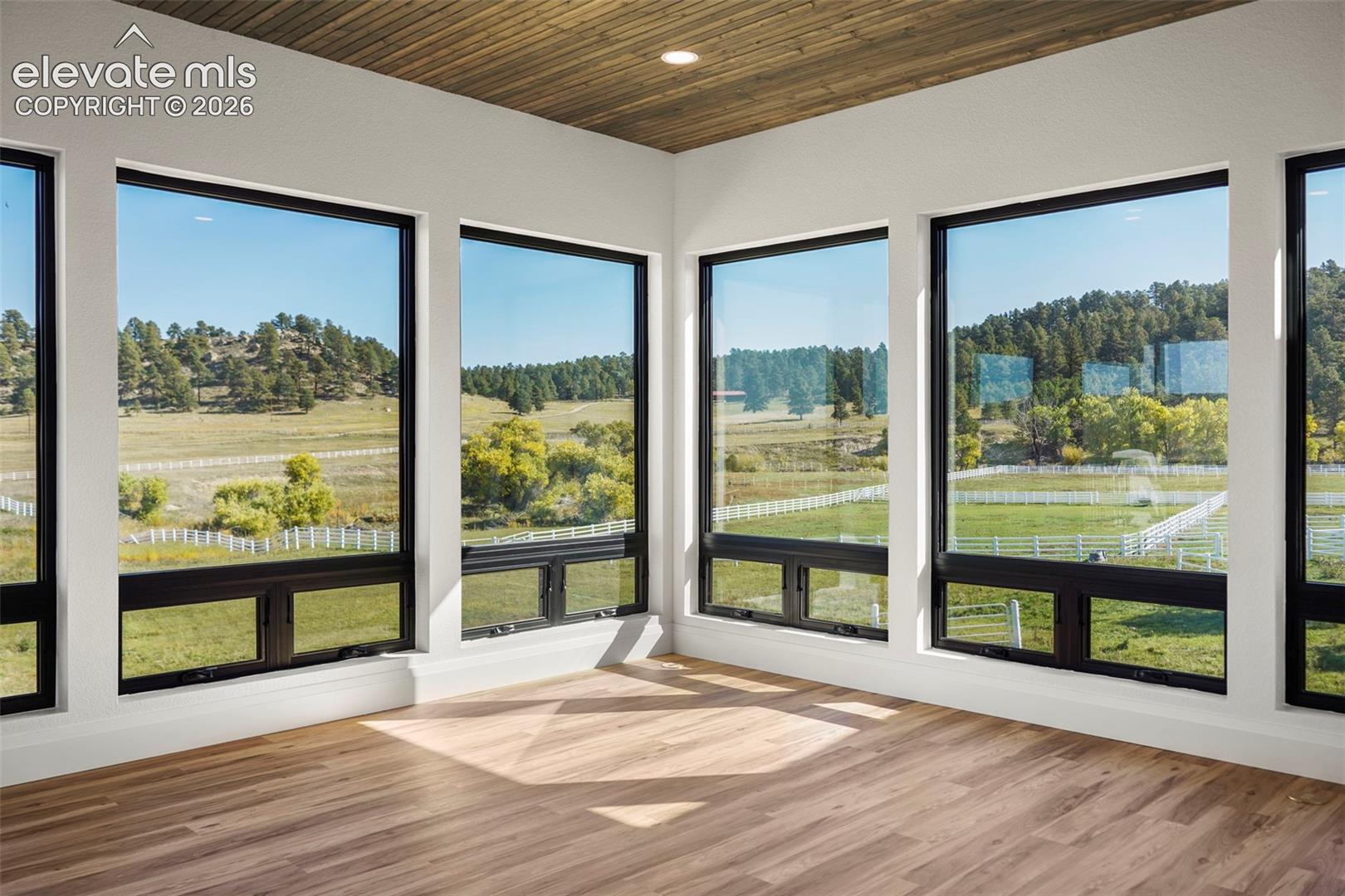 Wood-finish flooring, white walls, and a wood-paneled ceiling