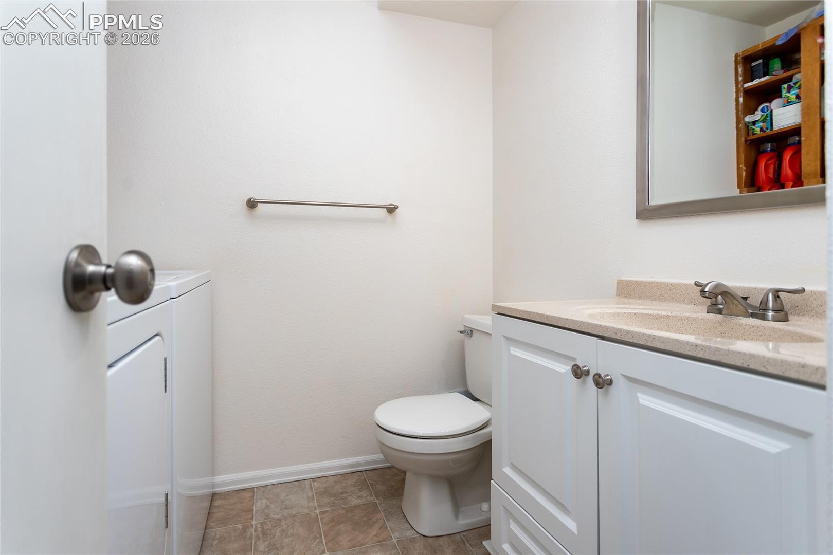 Half bathroom featuring vanity and toilet