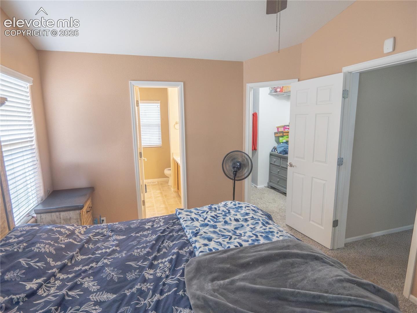 Carpeted room with vaulted ceiling and neutral wall paint