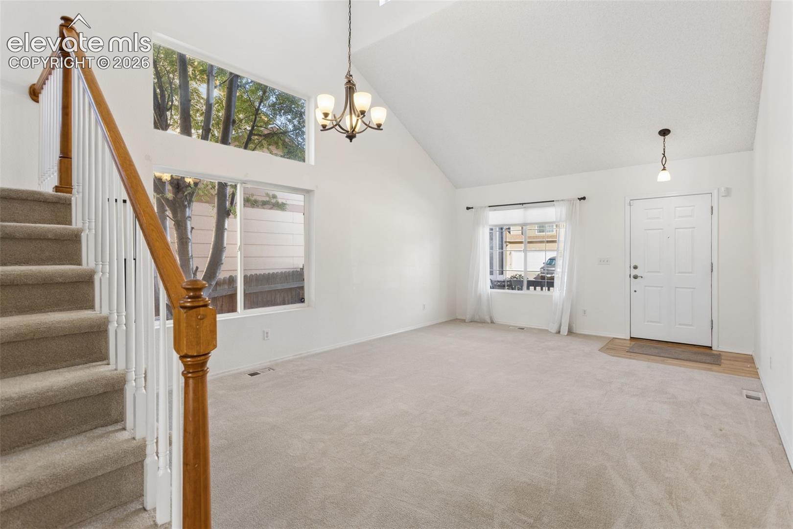 Front entry into living and dining room with vaulted ceilings