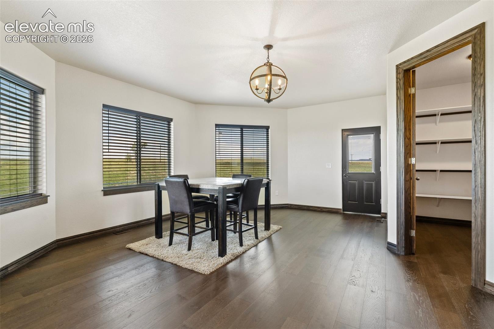 Dining area with dark wood-finish flooring and white walls