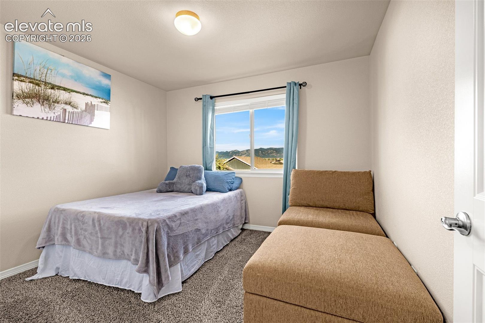 Wall-to-wall carpeting and a single window with curtain rod
