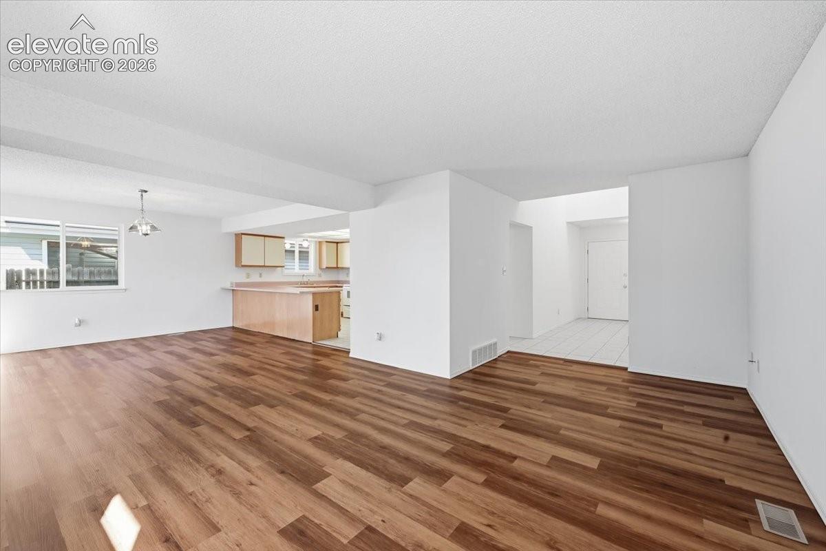 Open-concept kitchen and living area flow with new flooring throughout at , Colorado Springs, CO.