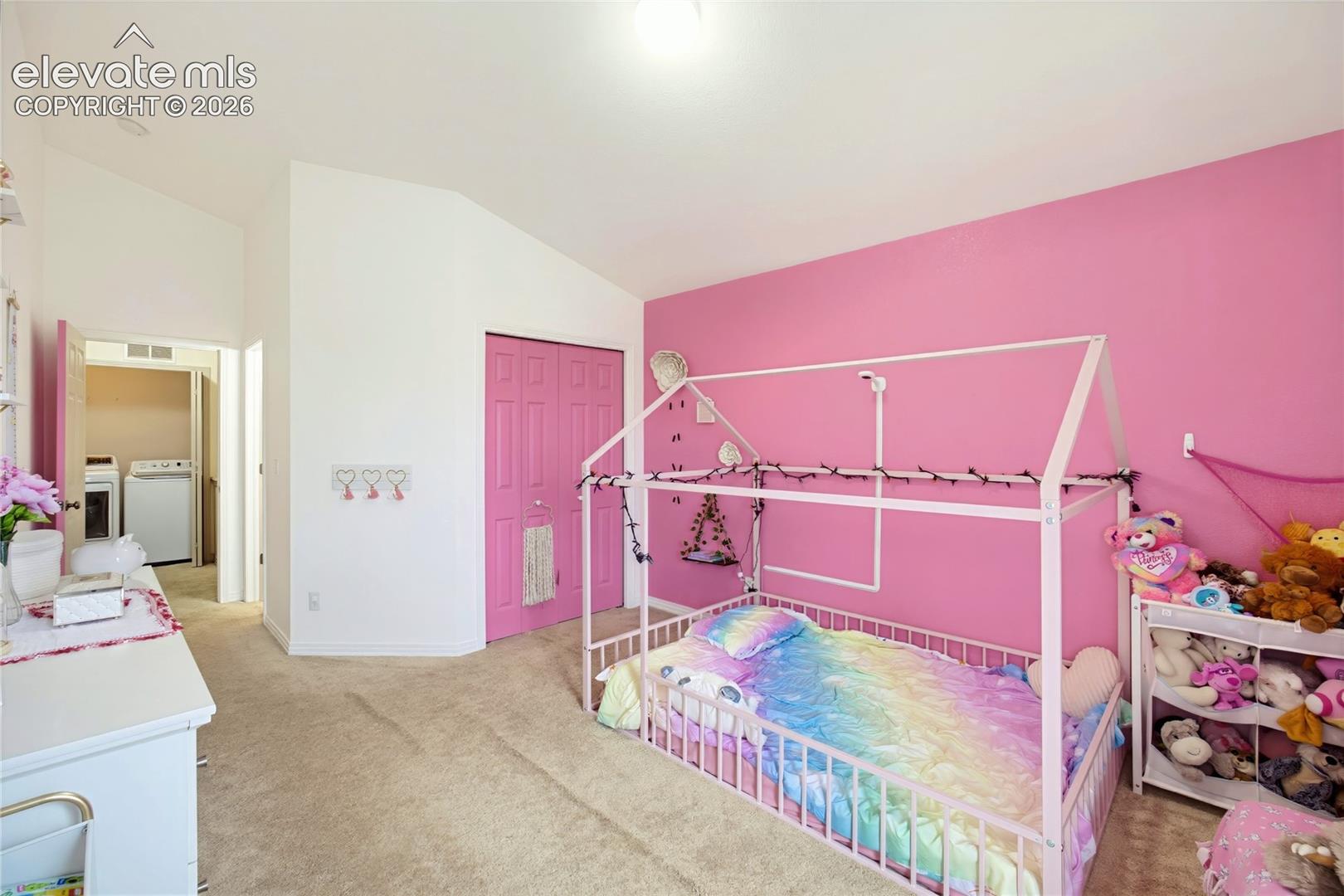 Plush carpet flooring, vaulted ceiling, and bi-fold closet doors