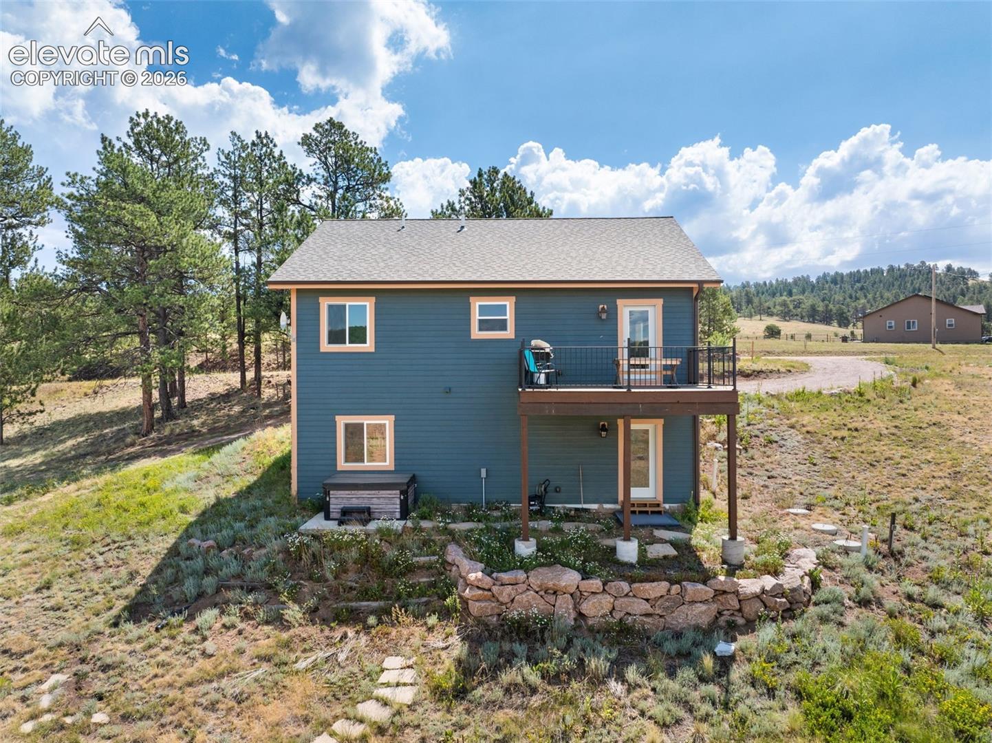 Walkout lower level with an elevated deck and patio below.