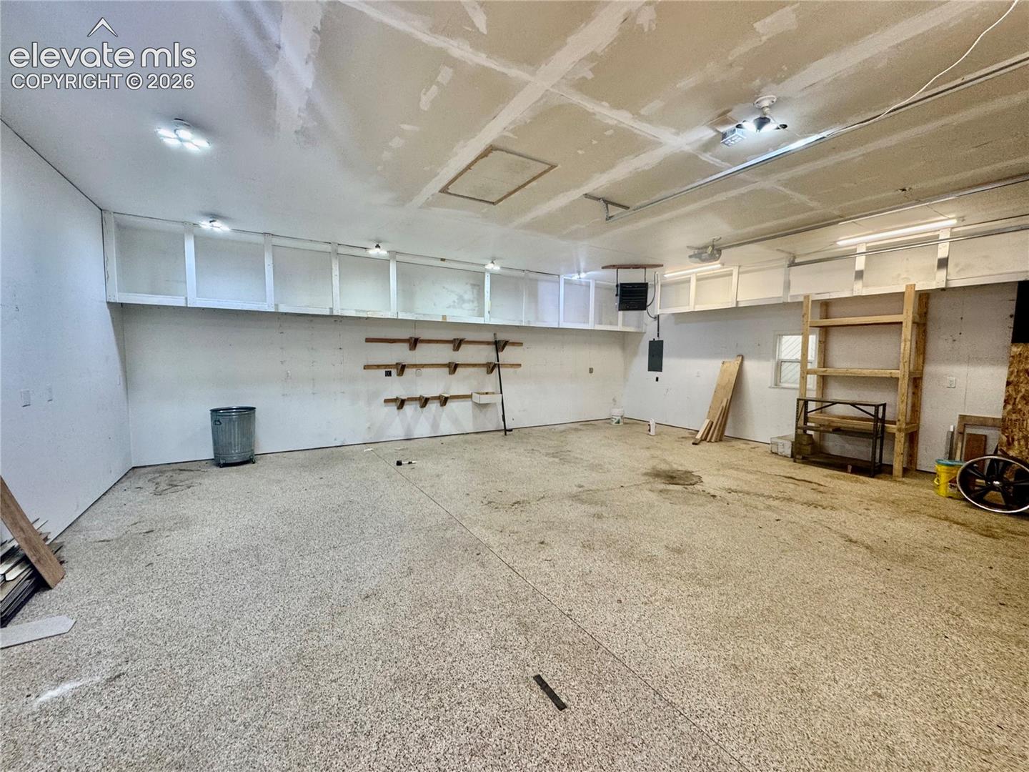 Detached Garage/Shop interior space with overhead storage cabinetry, wall-mounted shelving, and recessed lighting fixtures