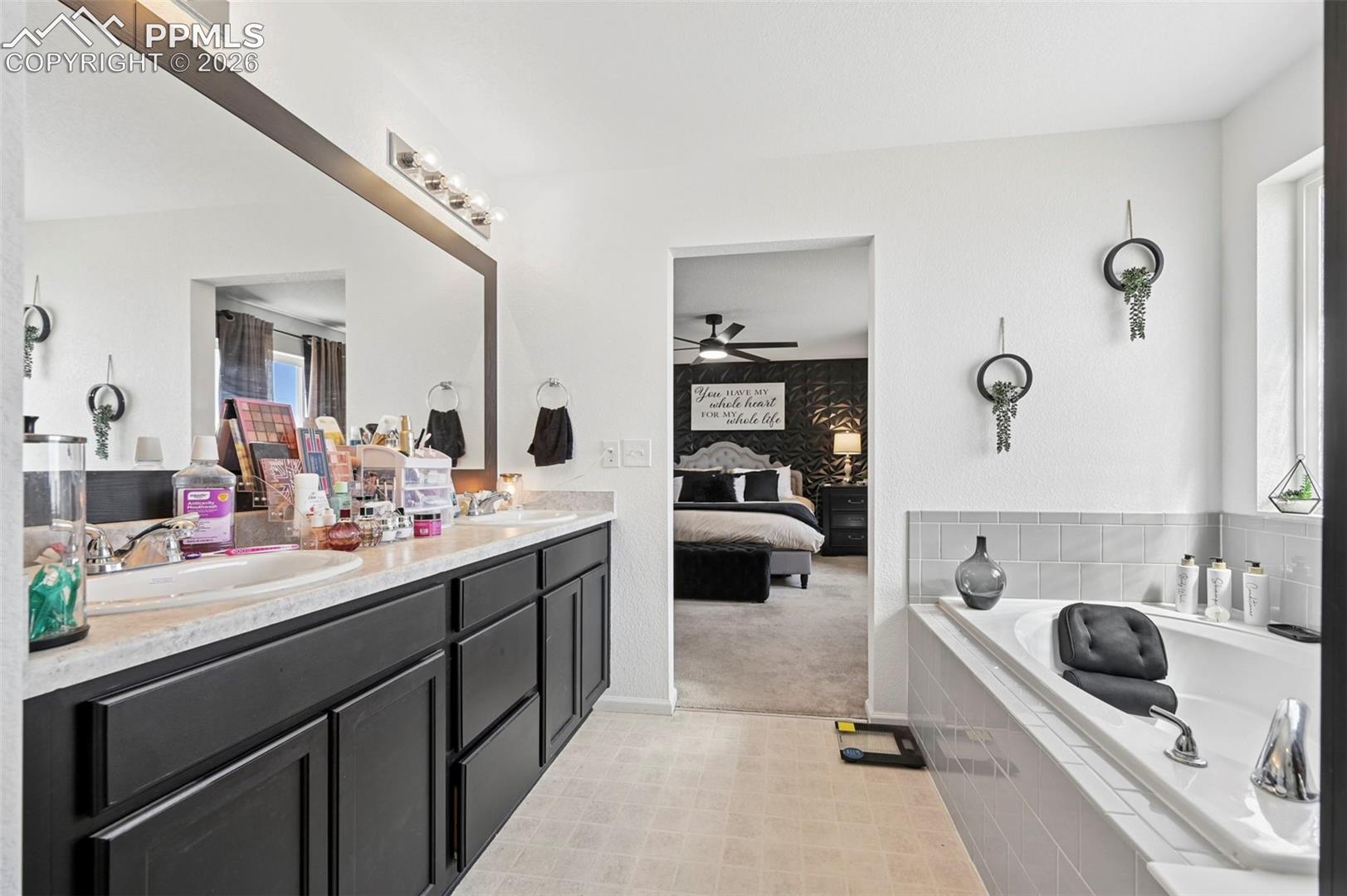 Bathroom featuring a dual vanity with dark wood-finish cabinetry and a framed mirror