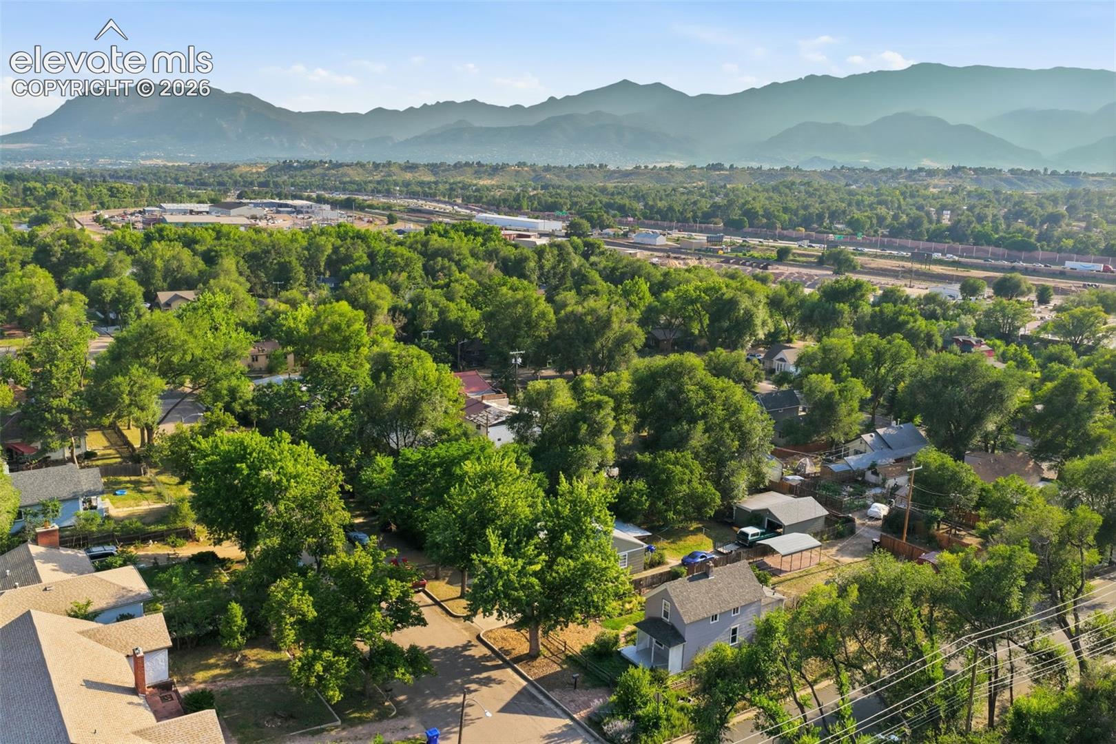 Tree-lined neighborhood with a backdrop of distant mountains.