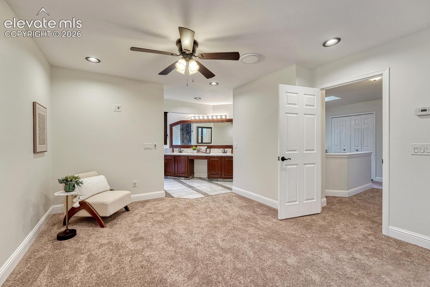 Neutral carpeting, recessed lighting, and a ceiling fan with integrated light fixture