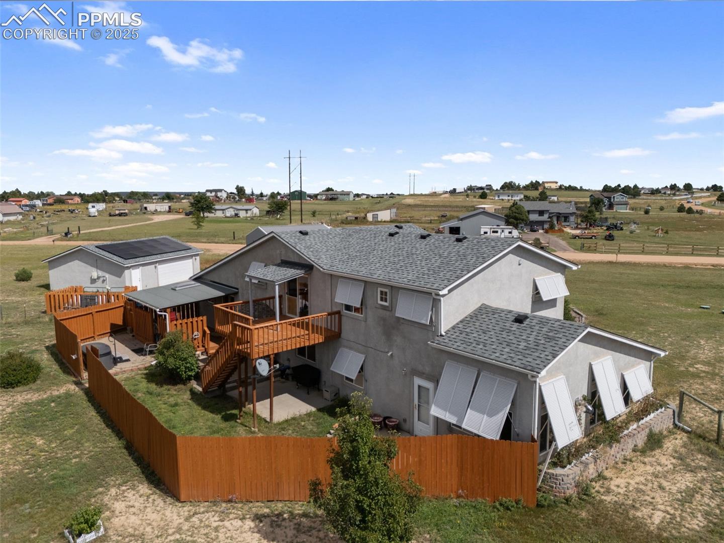 Backyard aerial with deck, fencing, and open space
