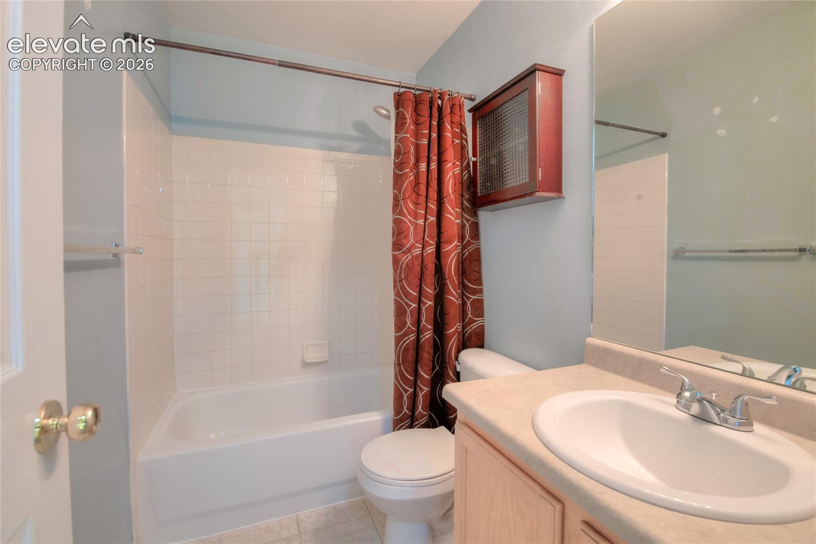 Full bathroom featuring a single vanity with a laminate countertop, an integrated sink, a built-in medicine cabinet, a toilet, and a tub/shower combination with white tile surround