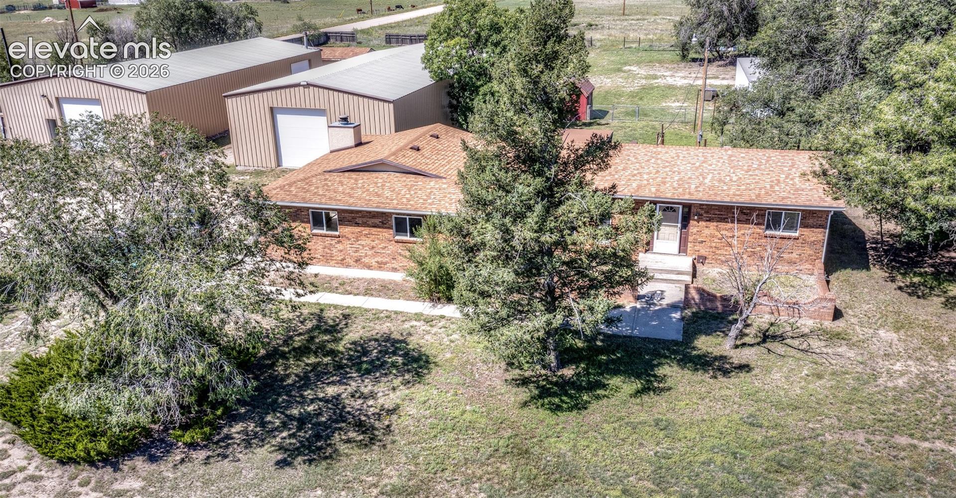 Totally remodeled 1888 sq ft 3 bed, 2 bath,  stucco & brick rancher on 4.77 acres with no HOA or covenants.  Huge outbuildings including 2 top of the line Red Iron steel buildings. Building #1 is 80x40, fully insulated with sheet rocked walls, 4" roof insulation & 10" of wall insulation, two 12x12 sectional roll up doors, 8" concrete floor with fiber, 140,00 BTU Reznor waste oil heater, 200 amp elect service, 8,000 pound four post lift, 25x12 mezzanine & 17x6 tool/engine room~ Building #2 is 72x35 & has 4" insulation in ceiling & walls, two 12x12 sectional roll up doors w/openers, rebar concrete floor, 100 amp service, 30 amp RV outlet & 24x8 mezzanine.  There are also multiple sheds & storage buildings.  Property is fenced & cross fenced.  The home has brand new stainless steel kitchen, new LVP & carpeting, fresh paint & vinyl windows with blinds, 20x14 covered deck with mountain views, oversized attached drywalled 2 car garage with slop sink ~ corner lot zoned A-35 on paved road, close to Schriever or Peterson. No HOA or covenants- Bring your cars, boats, campers, toys, horses, goats, etc & enjoy your country lifestyle in less than 30 minutes from Powers Blvd. Great "Move In" ready property. Seller will do walk thru with buyers to explain everything.