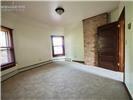 Exposed brick chimney feature with natural wood-tone door and multiple windows with dark-finish trim