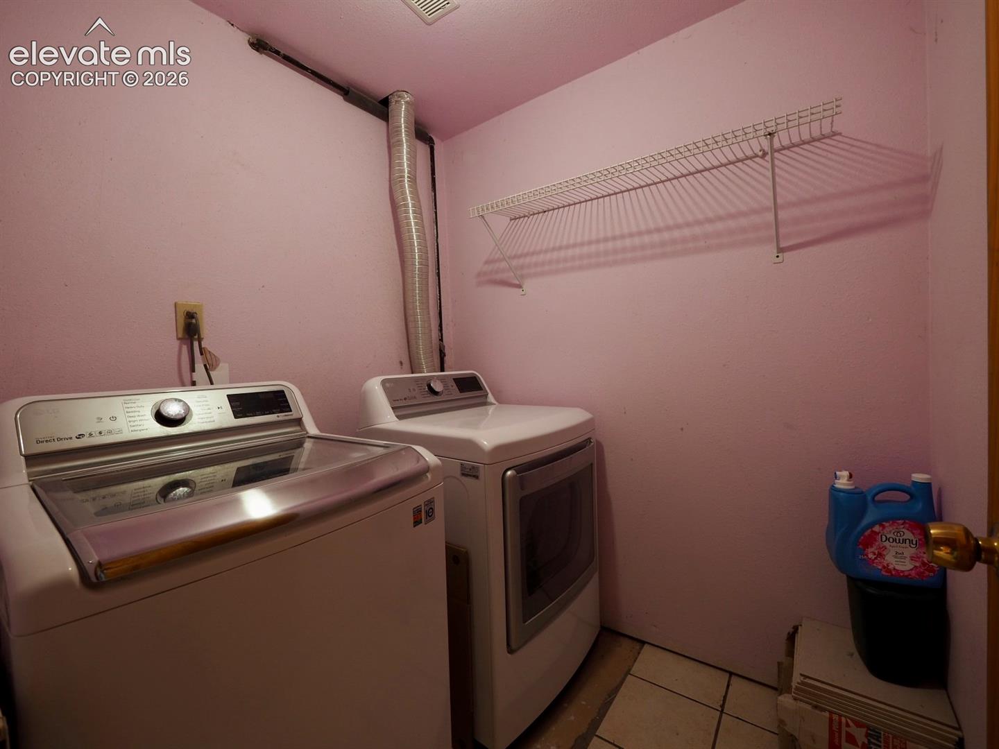 Laundry space featuring wire shelving and tile flooring