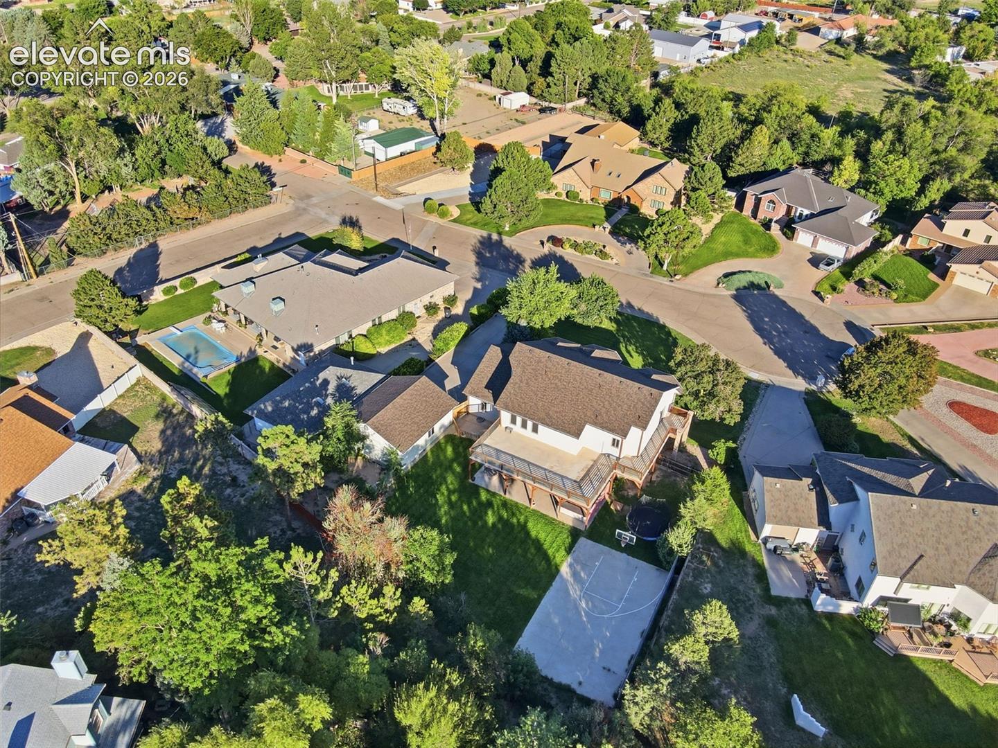 Expansive property with a basketball court, mature trees, and a multi-level deck