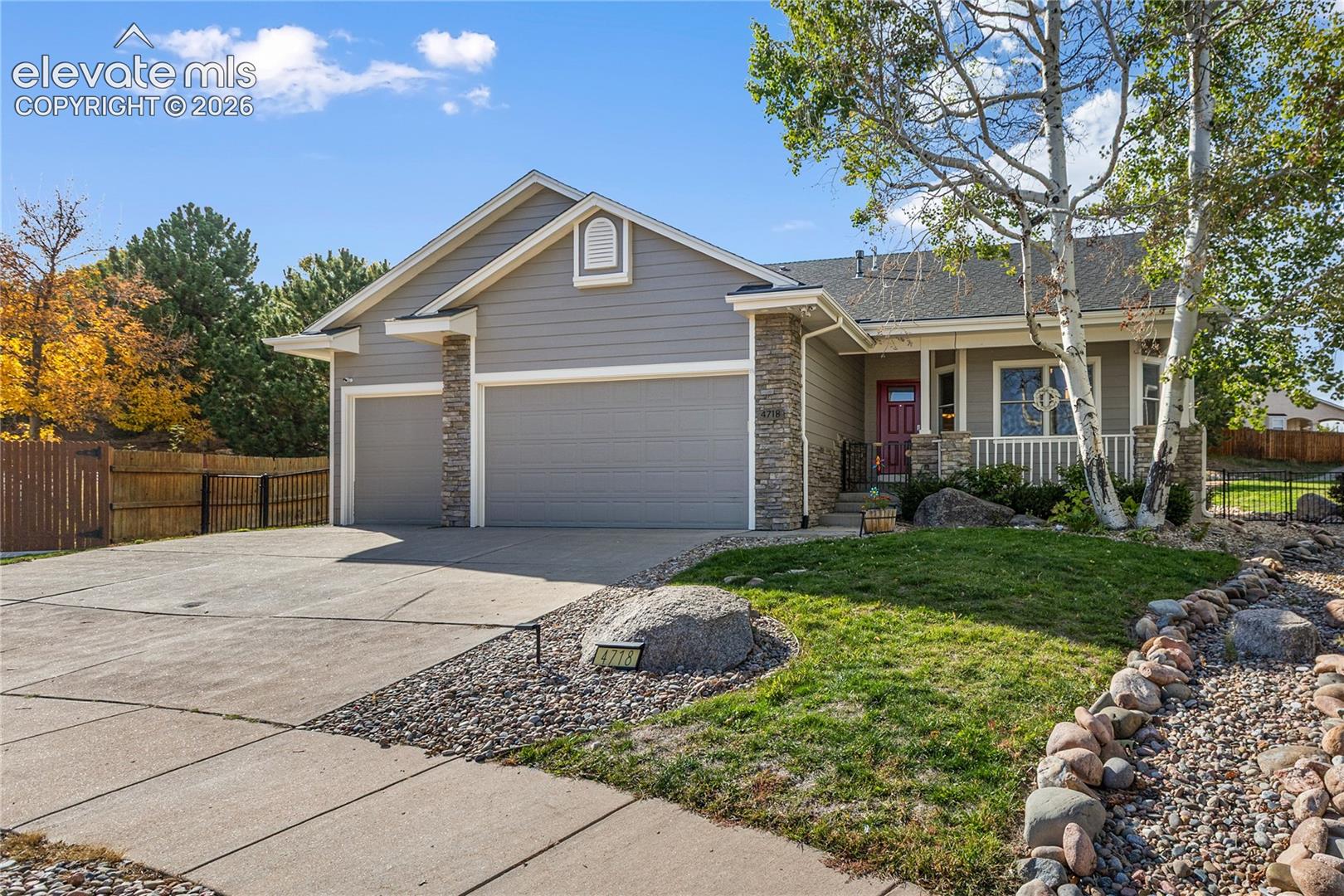 Located on a quiet cul-de-sac in Sierra Ridge, this inviting 4-bedroom, 3-bath home offers 3,120 square feet of well-designed living space, tasteful updates, and exceptional outdoor entertaining areas. The open main level features vaulted ceilings, abundant natural light, and a striking stone-surround fireplace with custom built-in shelving. The kitchen offers granite countertops, stainless steel appliances, warm wood cabinetry, hardwood flooring, and a breakfast bar overlooking the living area. The primary suite features a beautifully updated bath with dual granite-topped vanities, a freestanding soaking tub, and an oversized glass-enclosed tile shower. A separate sitting room provides a flexible third living area, ideal for a home office or reading retreat.The finished basement includes a spacious recreation area and custom wet bar with granite countertops, built-in shelving, and bar seating. The large mechanical room offers generous additional storage with extensive shelving.The beautifully landscaped backyard backs to green space and features an expansive stamped-concrete patio, natural boulder retaining walls, mature trees, winding garden paths, a lush lawn, and privacy fencing. A covered stamped-concrete front porch adds to the home's welcoming appeal. Additional highlights include a three-car garage, multi-camera security system, outdoor storage closet, and included gas grill, washer, and dryer. Nearby Norwood recreation amenities include a seasonal pool, tennis and pickleball courts, and clubhouse. Convenient to shopping, dining, schools, and everyday amenities, this home combines versatile interior space with outstanding outdoor living.
