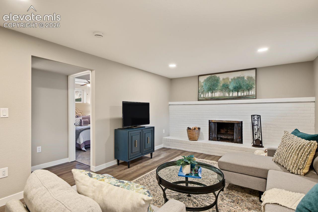 Painted brick faux fireplace featuring a raised hearth and wood-finish flooring