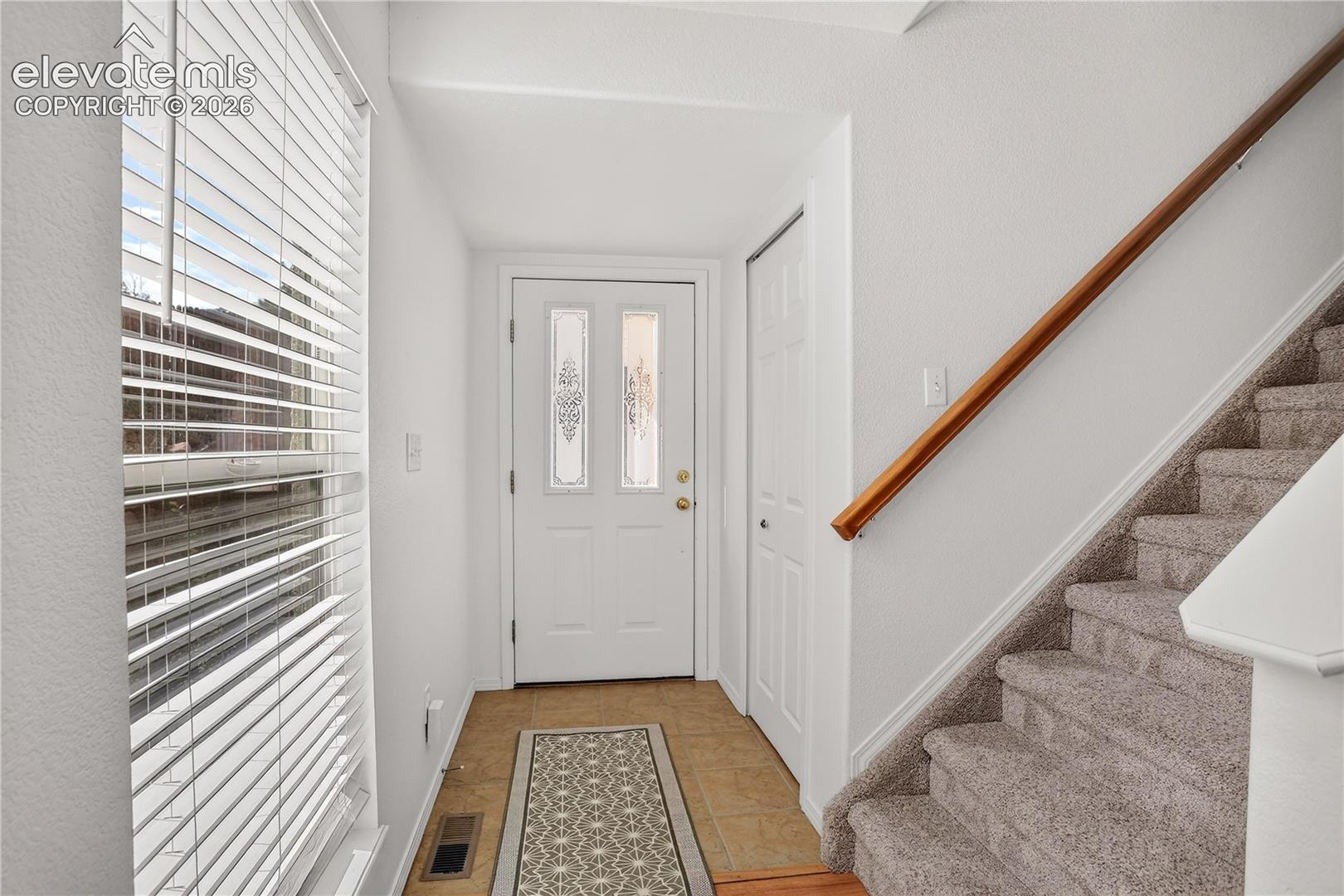 Front door entry with coat closet and ceramic tile flooring.