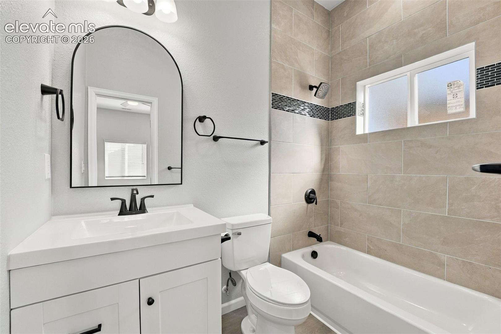 White vanity with an integrated sink and matte black faucet